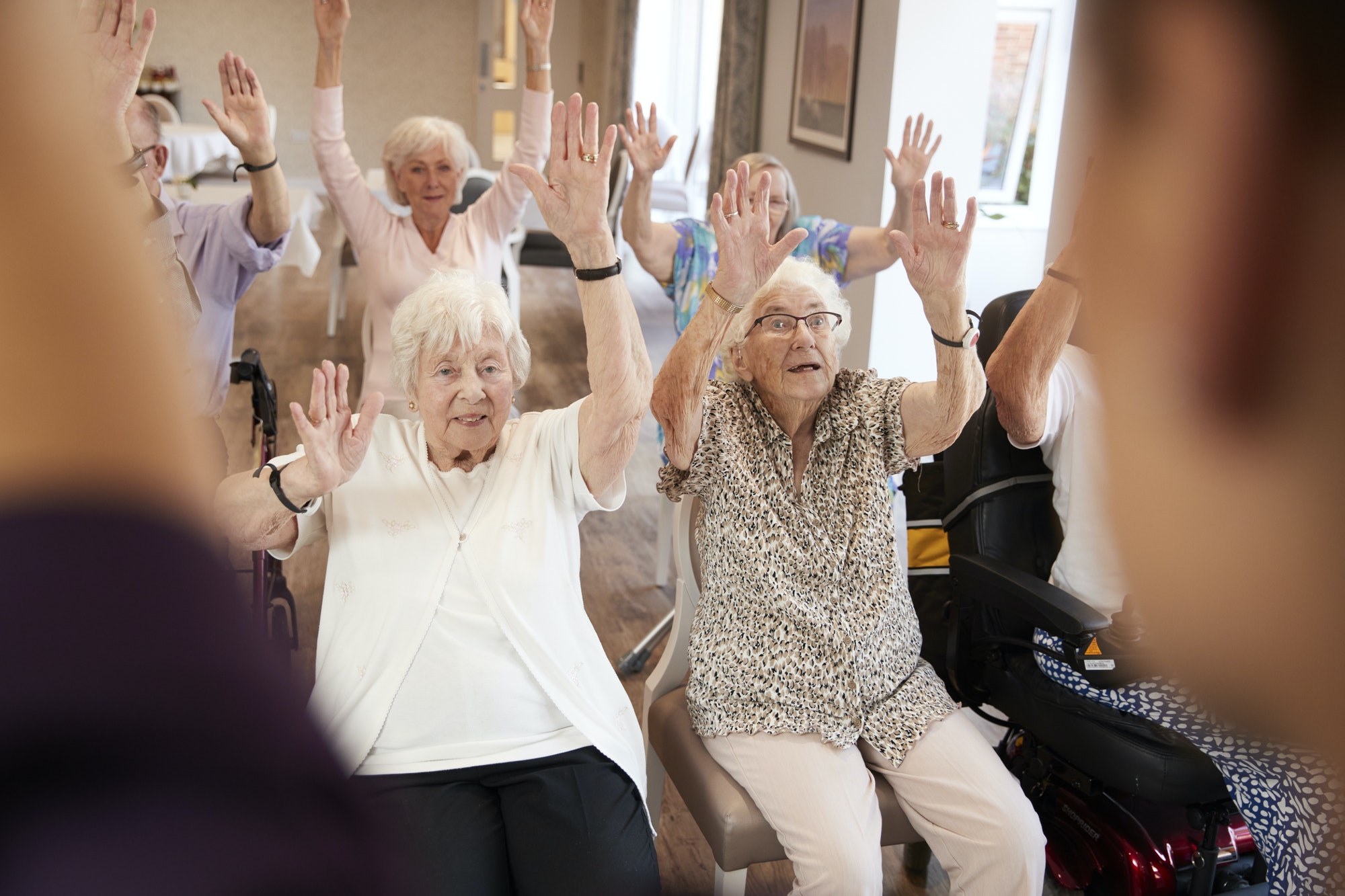 carer-leading-group-of-seniors-in-fitness-class-in-retirement-home.jpg